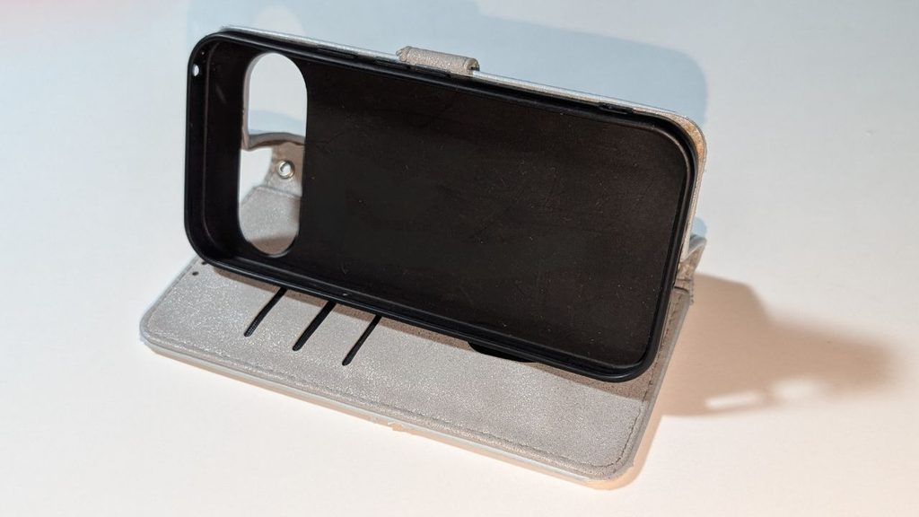 白い背景の上で開いた状態の手帳型スマホケースを斜め前から撮影した写真
