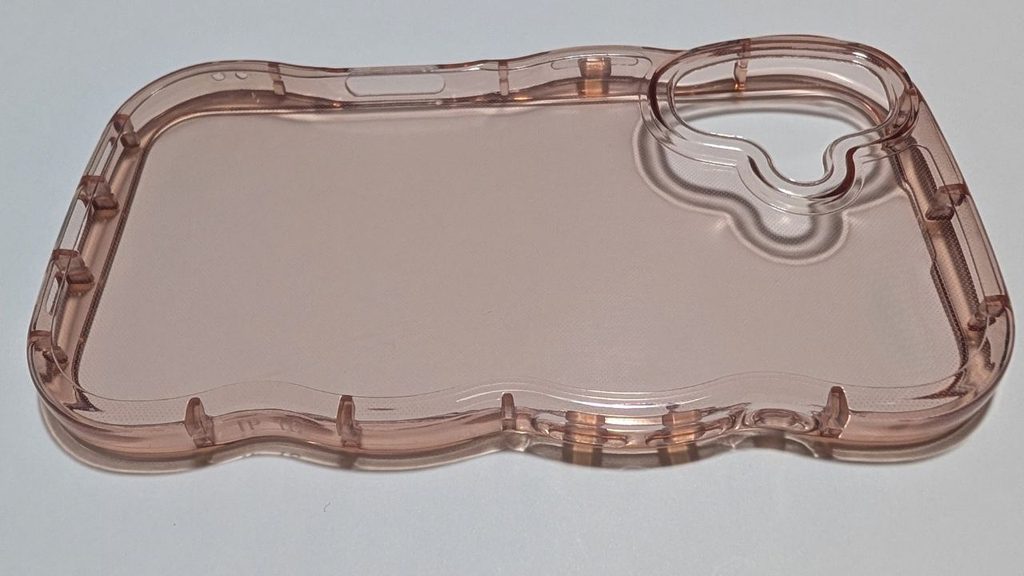 淡いピンク系の透明スマホケースの内側とカメラ開口部。縁の形状や盛り上がりが確認できる